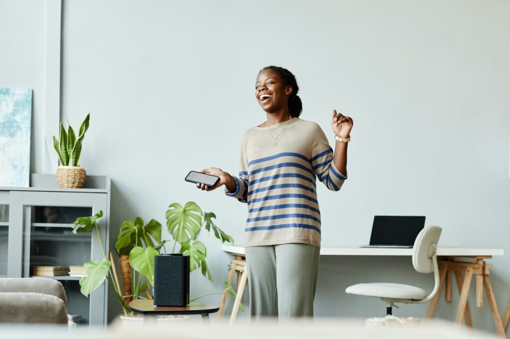 Carefree Woman Dancing to Smart Speaker at Home