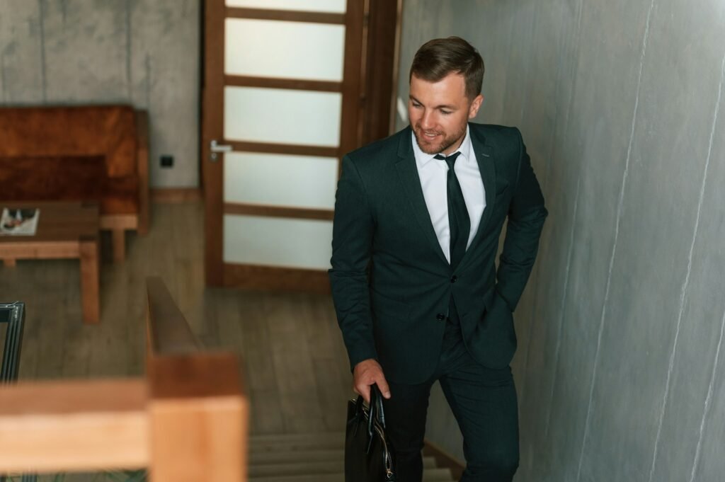 Front view, in the appartment. Handsome businessman is indoors in the hotel room